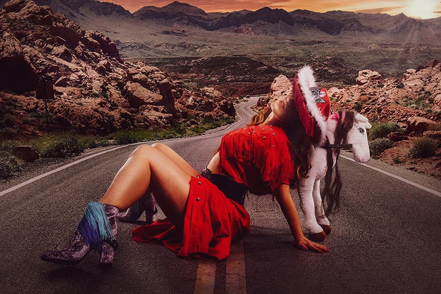 Cowgirl with a red suit posing in the middle of the roadway