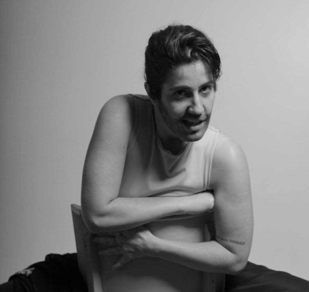 Good looking Drag King posing in a chair