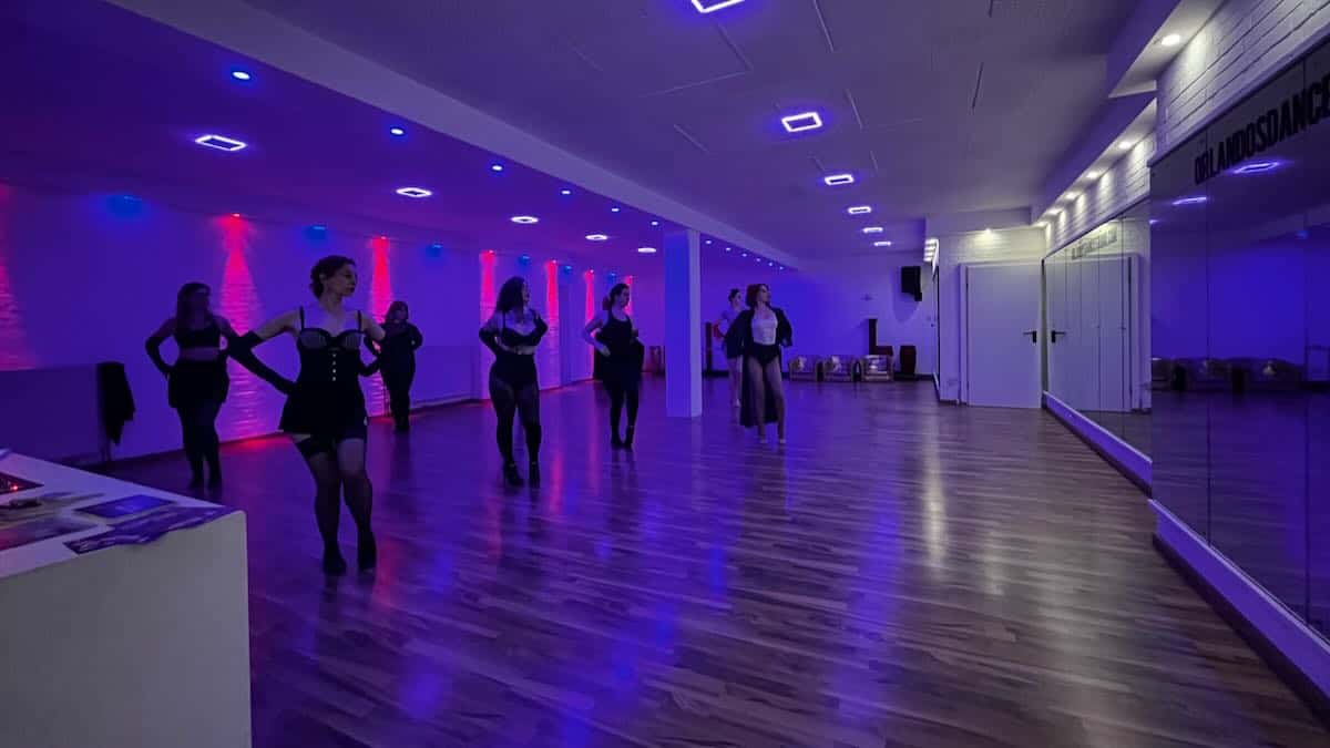 Group of ladies learning burlesque with the teacher in the middle.